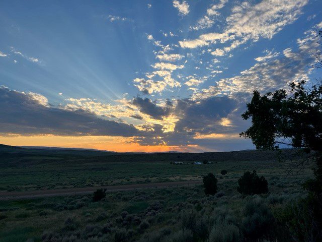 A sunset over the plains with clouds in the sky.