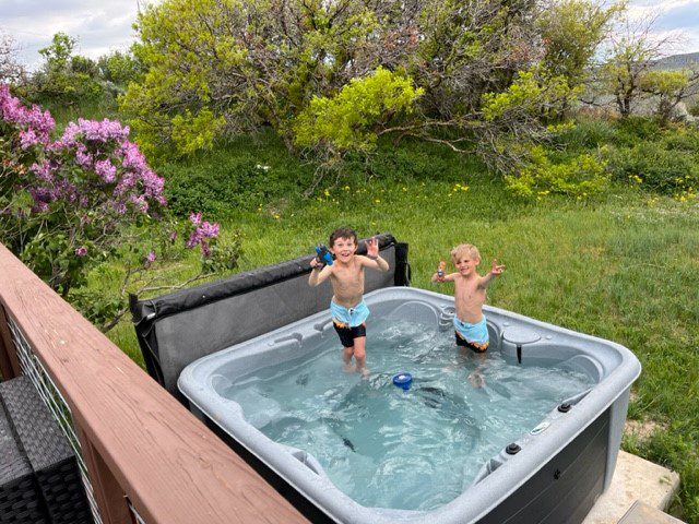 Two kids in a hot tub on the deck